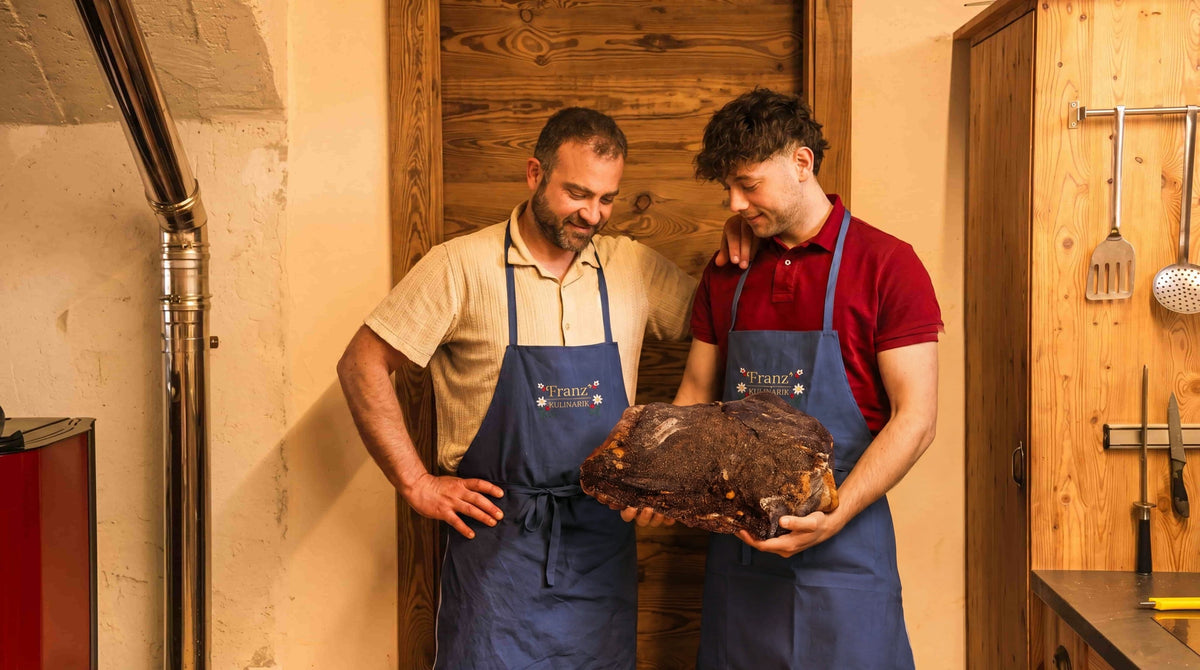 Patrick und Jan von Franz' Kulinarik mit einem Stück Speck